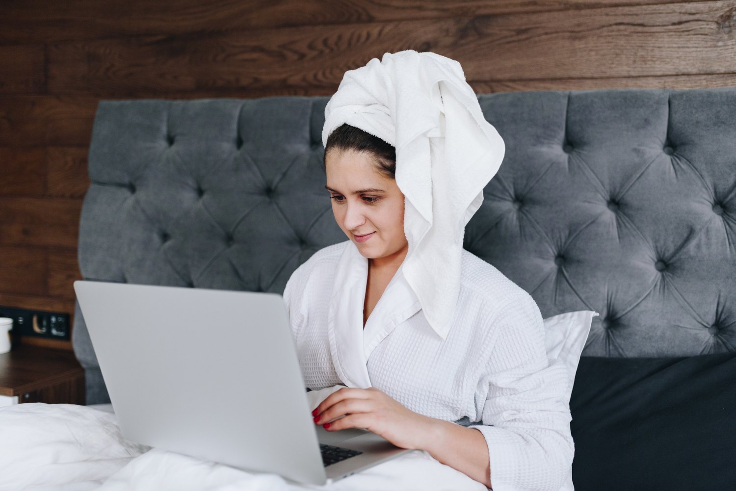 Kaugtöö - naine teeb tööd arvutiga voodis